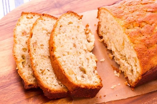 A slice of moist pineapple quick bread made with sour cream, showing a perfectly golden crust and a soft, tender crumb.