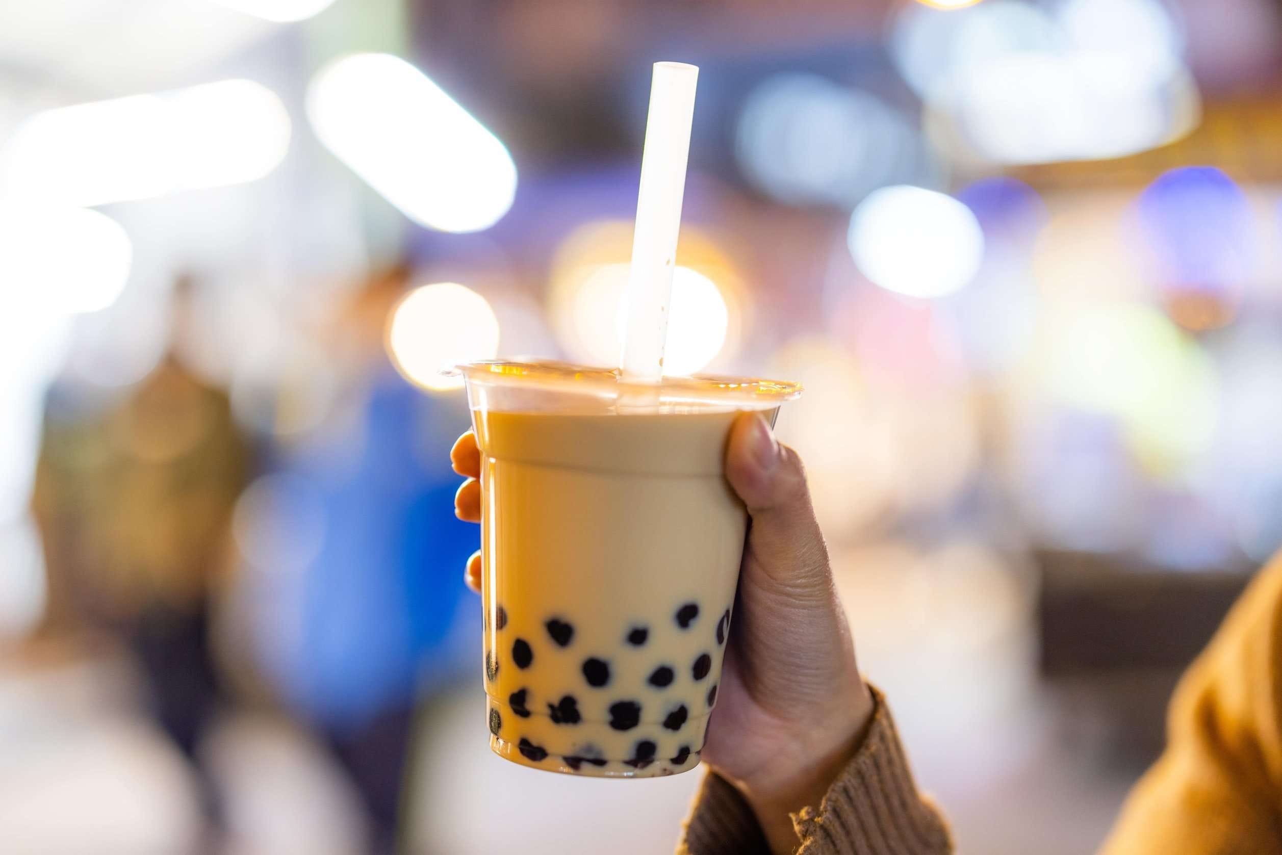 A refreshing glass of milk tea filled with chewy boba pearls at the bottom.