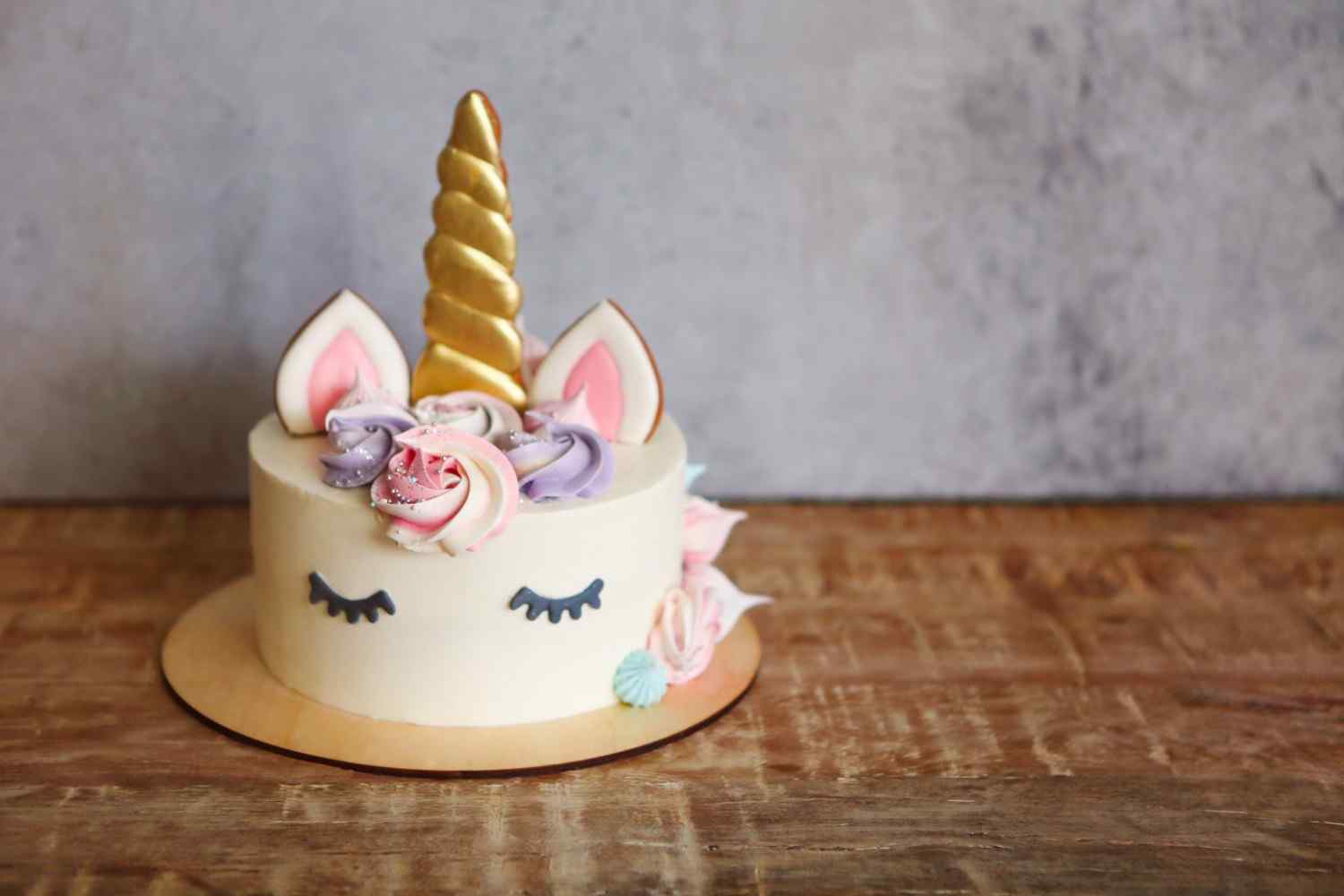 A colorful unicorn cake decorated with rainbow frosting and a golden horn.